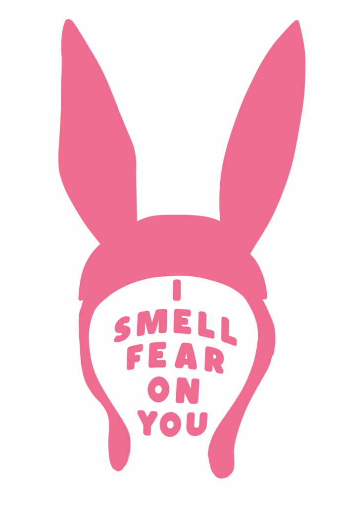 A bold pink silhouette of Louise Belcher’s signature bunny ear hat from Bob’s Burgers, with the phrase “I SMELL FEAR ON YOU” written in chunky, uppercase letters inside the face area. The background is solid black, making the vibrant pink stand out dramatically. The design gives off a humorous yet intimidating vibe.